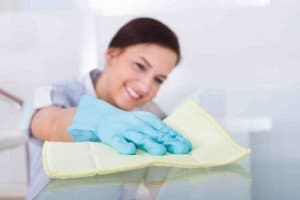 Maid Cleaning Glass Table